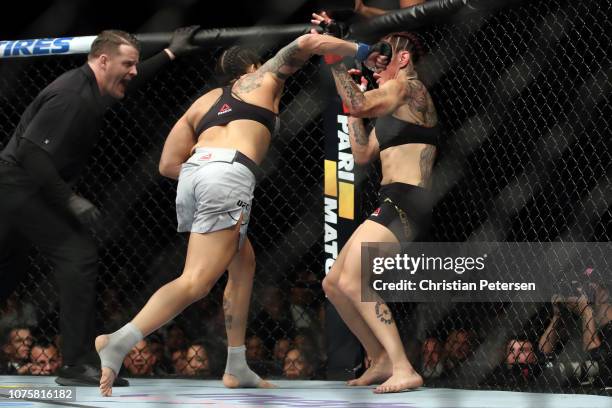 Amanda Nunes of Brazil punches Cris Cyborg of Brazil in their women's featherweight bout during the UFC 232 event inside The Forum on December 29,...