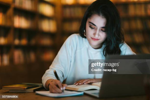 jonge college student studeert in bibliotheek - turkse etniciteit stockfoto's en -beelden