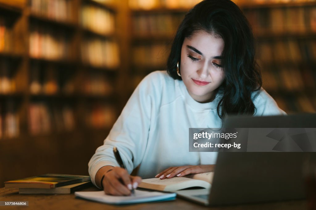 Young college student studying at library