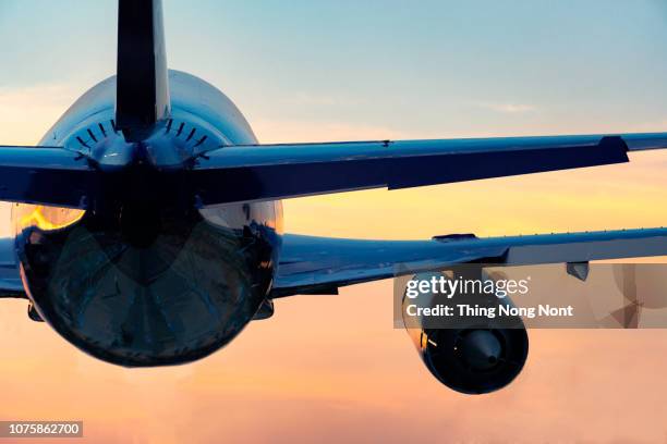 low angle view of airplane flying against sky during sunset - vehículo aéreo fotografías e imágenes de stock