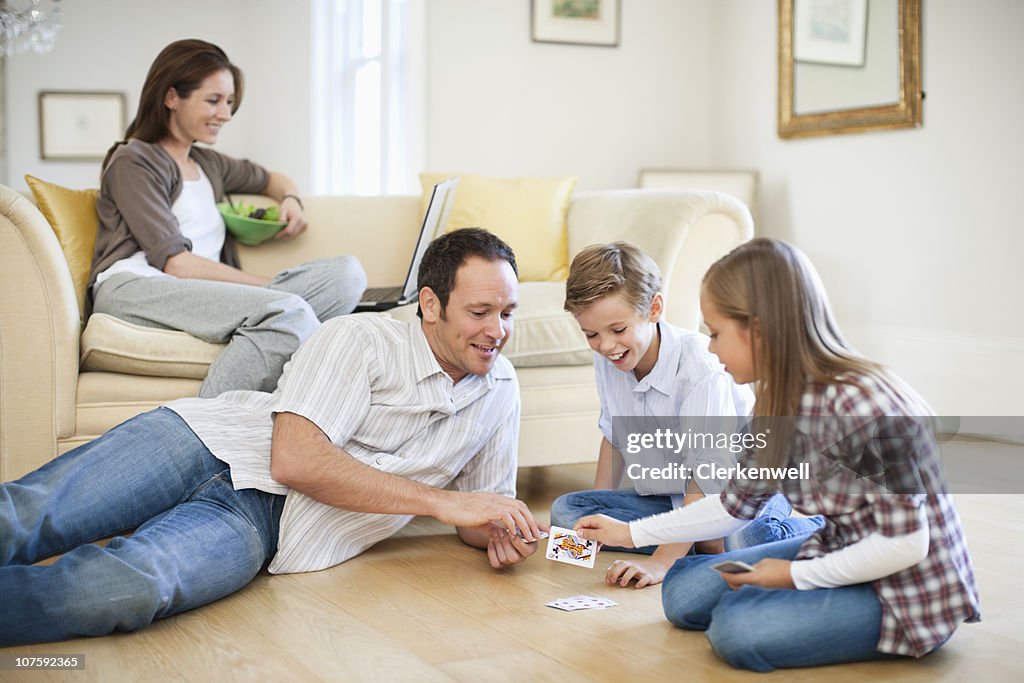 Pai Jogando um jogo de cartas com crianças (8- 11) com Mãe