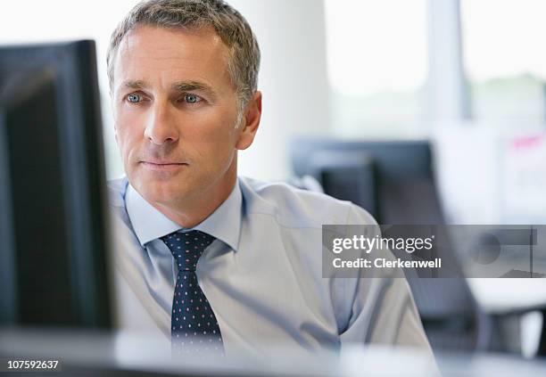 mature business executive looking at computer screen at office - shirt and tie stock pictures, royalty-free photos & images
