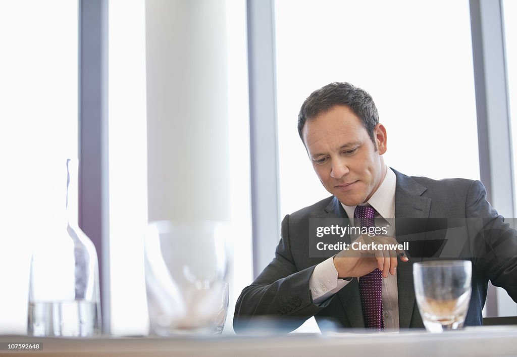 Serious businessman sitting at conference table in board room