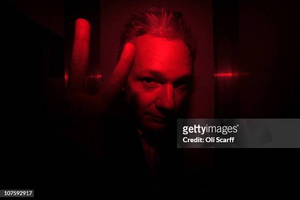 Wikileaks founder Julian Assange gestures inside a prison van with red windows as he leaves Westminster Magistrates Court on December 14, 2010 in...