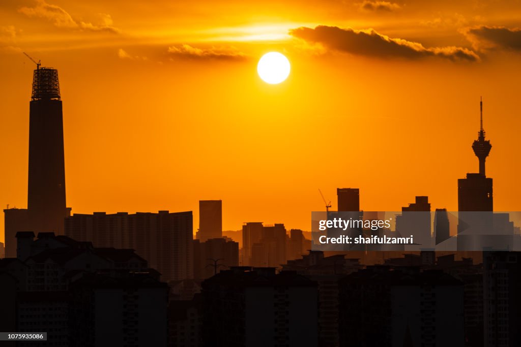 Majestic sunset over downtown Kuala Lumpur in silhouette.