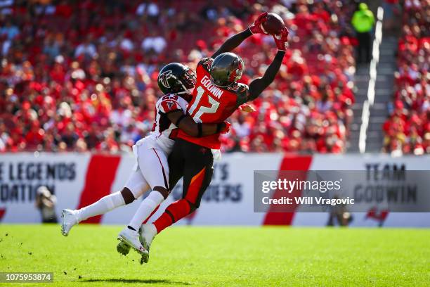 Wide receiver Chris Godwin of the Tampa Bay Buccaneers is wrapped up by cornerback Robert Alford of the Atlanta Falcons as he stretches for a pass...