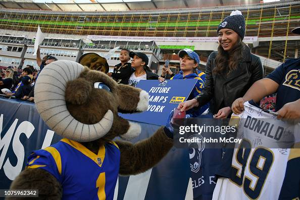 Rampage, the Los Angeles Rams mascot hands a phone to a young fan ...