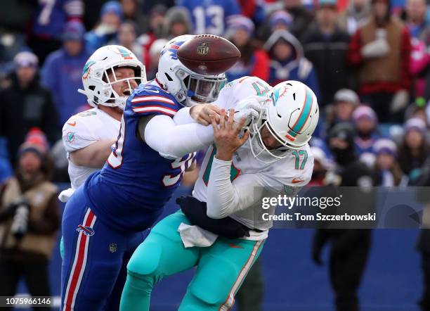 Ryan Tannehill of the Miami Dolphins is hit by Shaq Lawson of the Buffalo Bills and fumbles causing a turnover in the third quarter during NFL game...