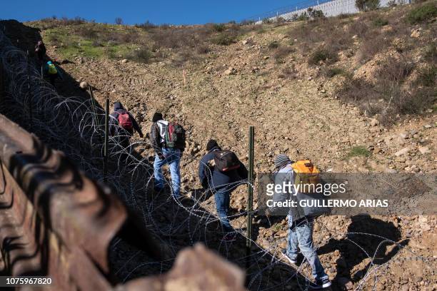 Family of Central American migrants hoping to reach the United States in hopes of a better life, walk after crossing the US-Mexico border fence from...