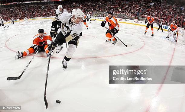 Sidney Crosby of the Pittsburgh Penguins skates with the puck in the corner against the defense of Darroll Powe and Kimmo Timonen of the Philadelphia...