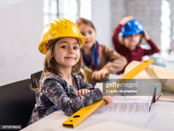 smiling little engineer working in the office. - adult imitation stock pictures, royalty-free photos & images
