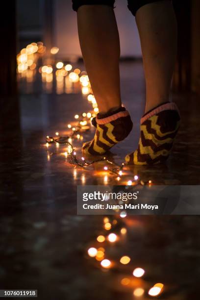 bare feet follow a path of lights - feet christmas stock-fotos und bilder