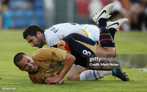 Michael Bridges of the Jets is tackled by Steve Pantelidis of the Gold Coast during the round 18 A-League match between the Newcastle Jets and Gold...