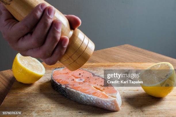 seasoning a fresh salmon steak with pepper - lachssteak stock-fotos und bilder