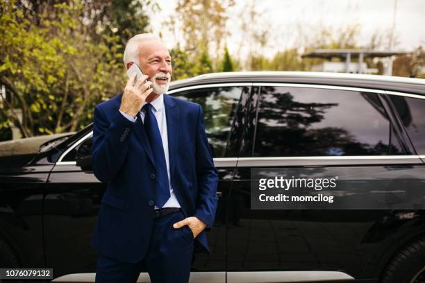 senior adult businessman talking on the phone - limousine exterior stock pictures, royalty-free photos & images