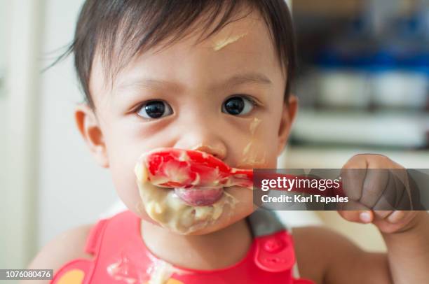 a baby boy learning to eat - funny baby faces stock pictures, royalty-free photos & images