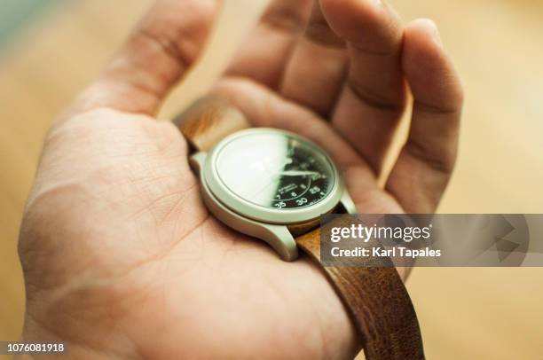 a mechanical watch held by human hand - wristwatch stockfoto's en -beelden