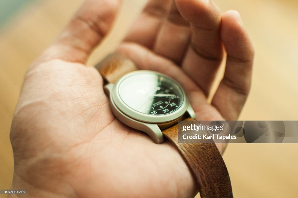 A mechanical watch held by human hand