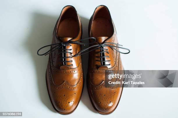 a still life of brown wingtip leather shoes - pair stockfoto's en -beelden
