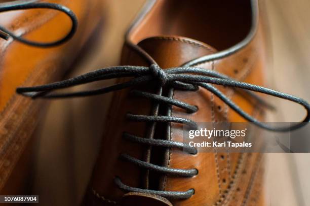 a close-up of a pair of men's shoes - brogue stock-fotos und bilder