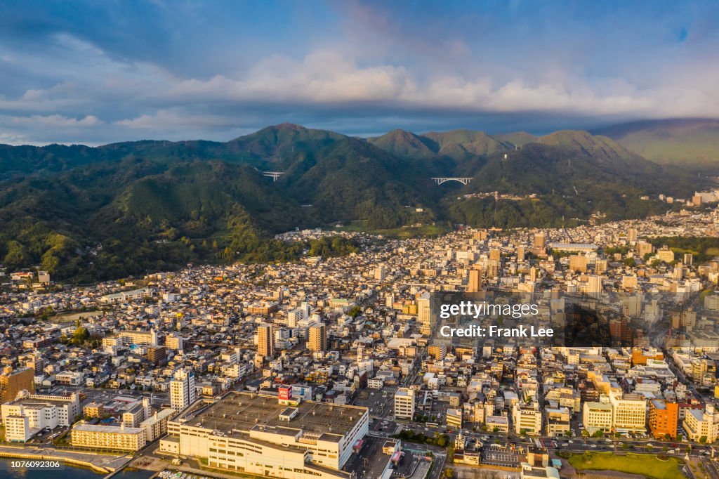 Aerial panorama view of Beppu cityscape from drone at sunset