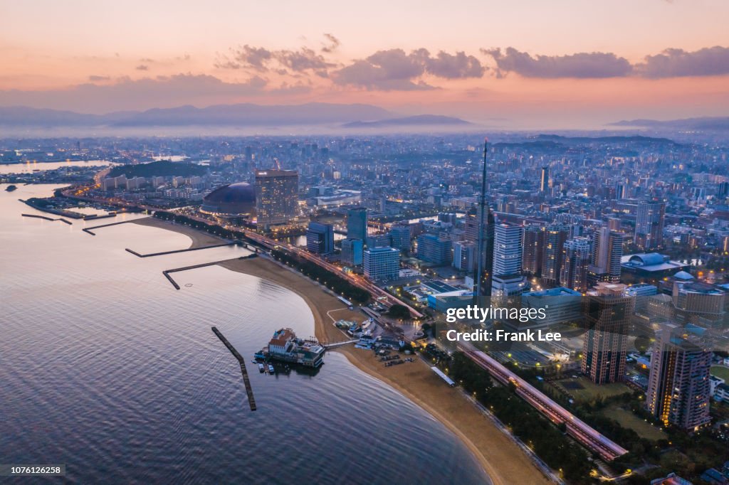 Panorama of Fukuoka tower aerial view from drone at sunset along with Momochi beach, Fukuoka prefecture, Japan