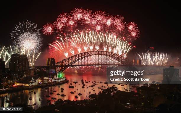 Fireworks explode over the Sydney Harbour Bridge during the midnight display on New Year's Eve on Sydney Harbour on January 1, 2019 in Sydney,...