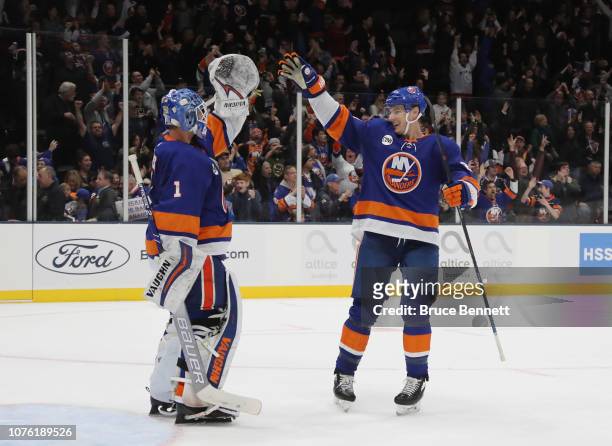 Thomas Greiss and Scott Mayfield of the New York Islanders celebrate their victory over the Columbus Blue Jackets at the Nassau Veterans Memorial...