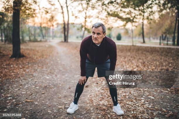 man resting after jogging - hand on knee stock pictures, royalty-free photos & images