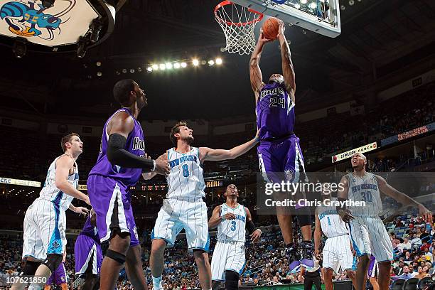 Carl Landry of the Sacramento Kings dunks the ball over Marco Belinelli of the New Orleans Hornets at the New Orleans Arena on December 15, 2010 in...