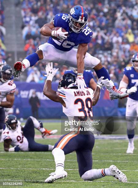 Saquon Barkley of the New York Giants leaps over Adrian Amos of the Chicago Bears for extra yardage during the third quarter at MetLife Stadium on...