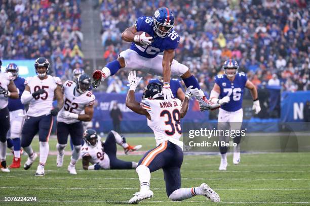 Saquon Barkley of the New York Giants leaps over Adrian Amos of the Chicago Bears for extra yardage during the third quarter at MetLife Stadium on...