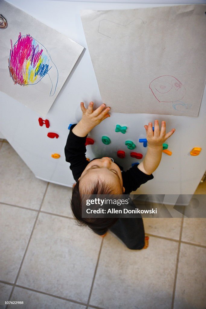 Baby boy reaching refrigerator