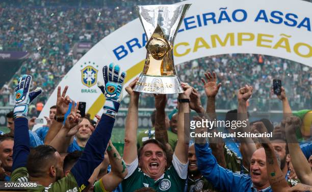 President elected of Brazil Jair Bolsonaro holds the trophy and celebrate with players of Palmeiras after winning the Brasileirao 2018 after the...