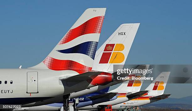 British Airways, left, and Iberia Lineas Aereas de Espana SA logos are seen on aircraft tailfins at Barajas airport in Madrid, Spain, on Thursday,...