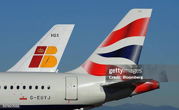 British Airways Plc, right, and Iberia Lineas Aereas de Espana SA logos are seen on aircraft tailfins at Barajas airport in Madrid, Spain, on...