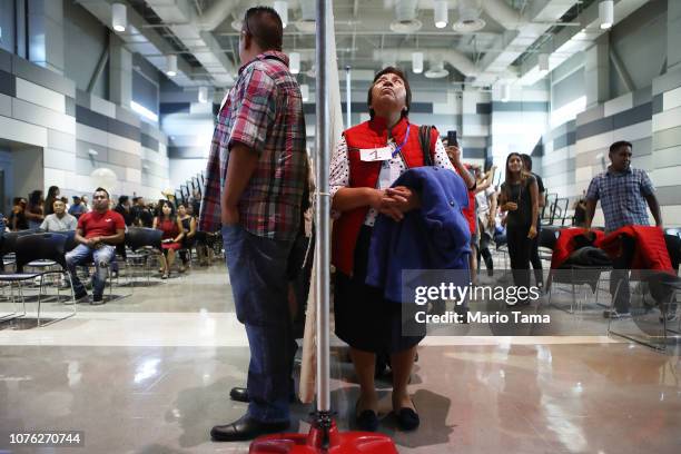 Family member from Mexico stands at a curtain as a family member living in the U.S. Stands at the other side before the curtain is dropped for the...