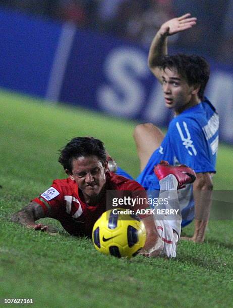Indonesia's Irfan Bachdim reacts against a Philippine defender during the first of the two round semi final games of the AFF Suzuki Cup 2010 football...