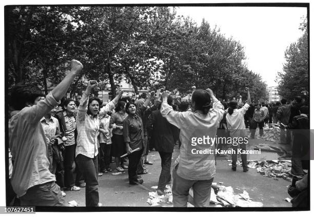 Female leftist students chant anti opression slogans while standing in rows with piles of newspapers and cardboards, ready to burn in case of tear...