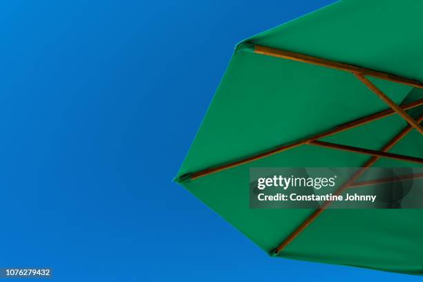 green beach umbrella against clear blue sky view from bottom - kota kinabalu beach stock pictures, royalty-free photos & images