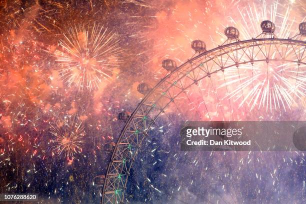 Fireworks explode over The London Eye and Elizabeth Tower near Parliament as thousands of revelers gather along the banks of the River Thames to ring...