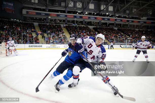 Aarne Talvitie of Finland and Mikey Anderson of the United States chase the puck and run into the boards together at the IIHF World Junior...