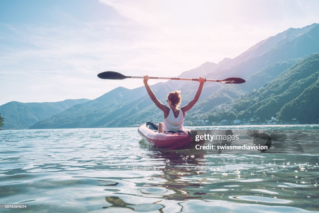Femme heureuse épris de canot sur le lac en été