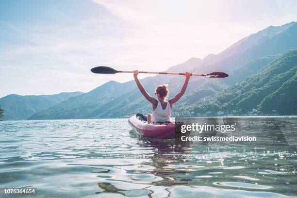 happy woman loving canoeing on lake in summer - red oar stock pictures, royalty-free photos & images