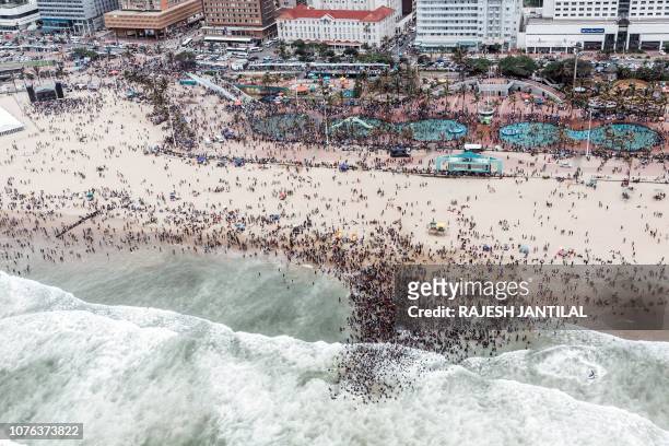 This aerial view shows thousands of revellers and holidaymakers gathering at the North Pier Beach during New Year Celebrations in Durban on January...