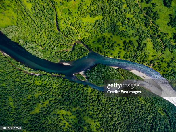 aerial view of a river snaking through a hilly forested landscape,kamchatka peninsula, russia - river aerial stock pictures, royalty-free photos & images