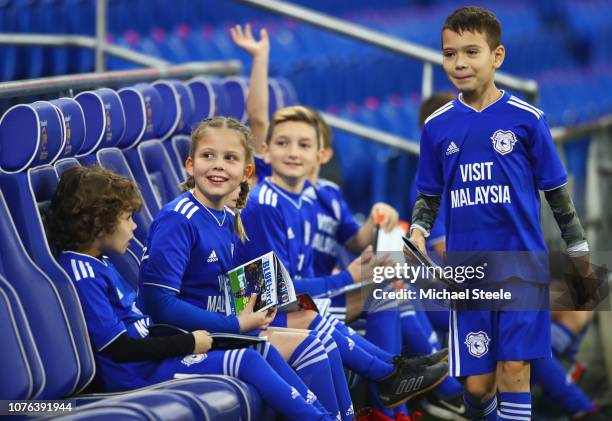 Young Cardiff City mascots sit on the bench prior to the Premier League match between Cardiff City and Tottenham Hotspur at Cardiff City Stadium on...
