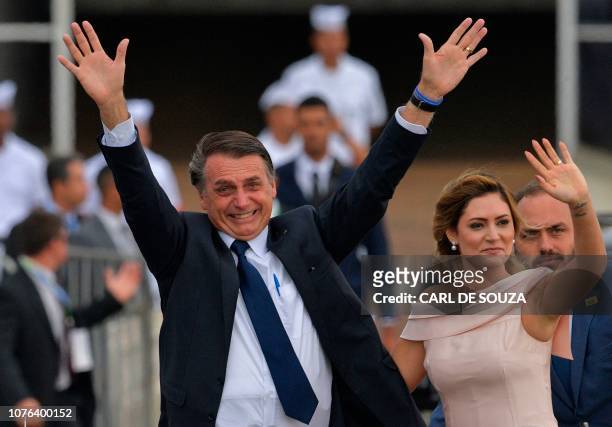 Brazil's President-elect Jair Bolsonaro gestures next to his wife Michelle Bolsonaro as the presidential convoy heads to the National Congress for...