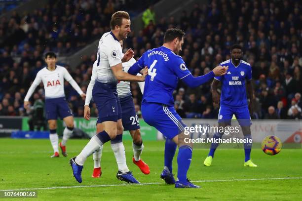 Harry Kane of Tottenham Hotspur beats Sean Morrison of Cardiff City as he scores his team's first goal during the Premier League match between...