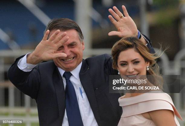 Brazil's President-elect Jair Bolsonaro gestures next to his wife Michelle Bolsonaro as the presidential convoy heads to the National Congress for...